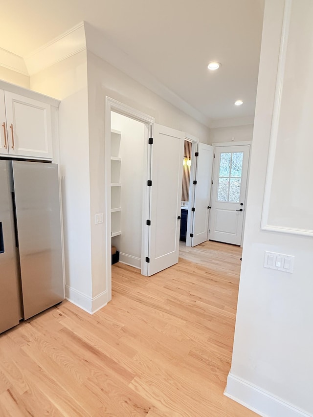 interior space with crown molding and light hardwood / wood-style floors