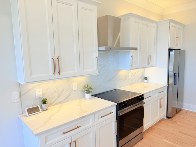 kitchen featuring white cabinets, stainless steel refrigerator with ice dispenser, wall chimney exhaust hood, and electric stove