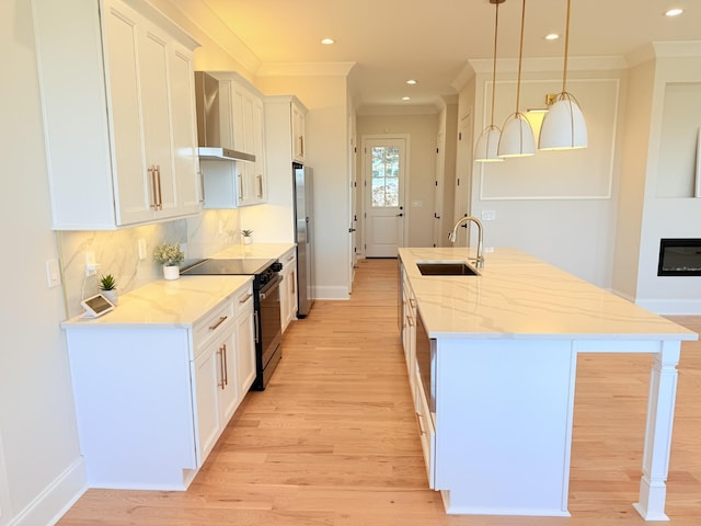 kitchen with sink, white cabinetry, light stone counters, electric range, and pendant lighting