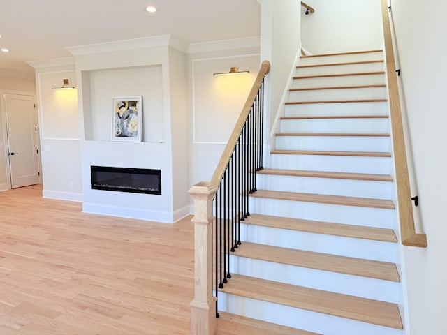 stairway featuring hardwood / wood-style flooring and ornamental molding