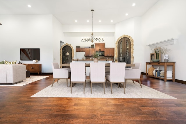 dining space featuring a towering ceiling and dark hardwood / wood-style floors