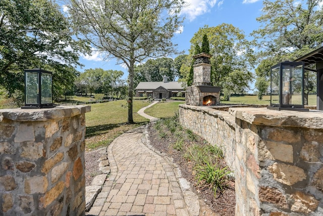 view of yard featuring an outdoor stone fireplace