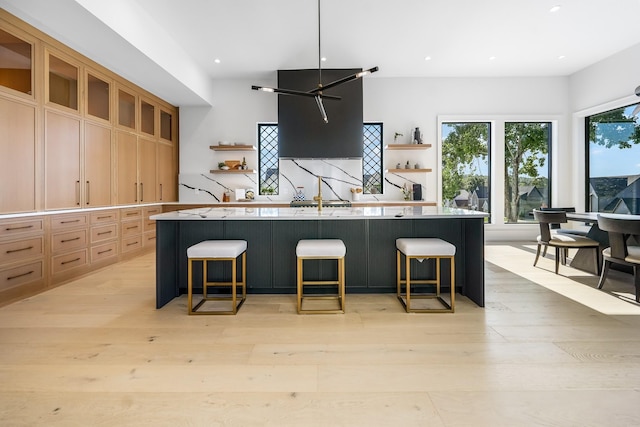 kitchen with a spacious island, a breakfast bar, and light wood-type flooring