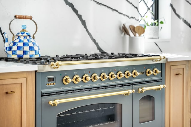 interior details featuring light brown cabinetry and range with two ovens