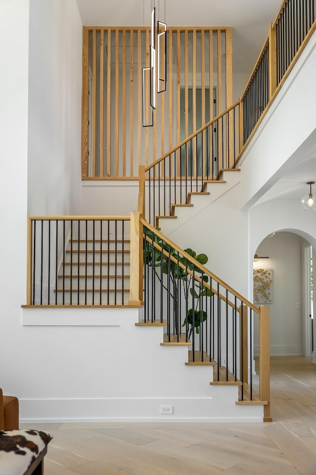 stairway featuring a towering ceiling