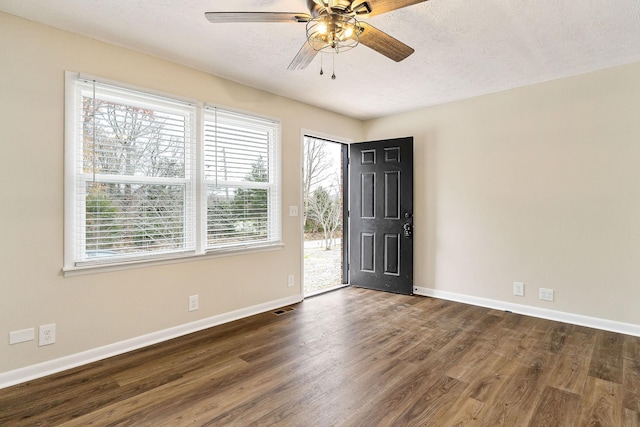 unfurnished room with ceiling fan, dark wood-type flooring, and a textured ceiling