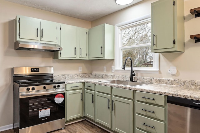 kitchen featuring appliances with stainless steel finishes, sink, green cabinets, and dark hardwood / wood-style flooring