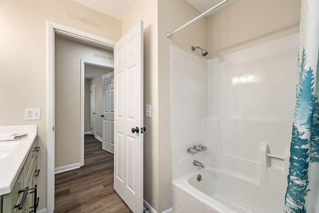 bathroom with hardwood / wood-style flooring, vanity, and shower / bathtub combination with curtain