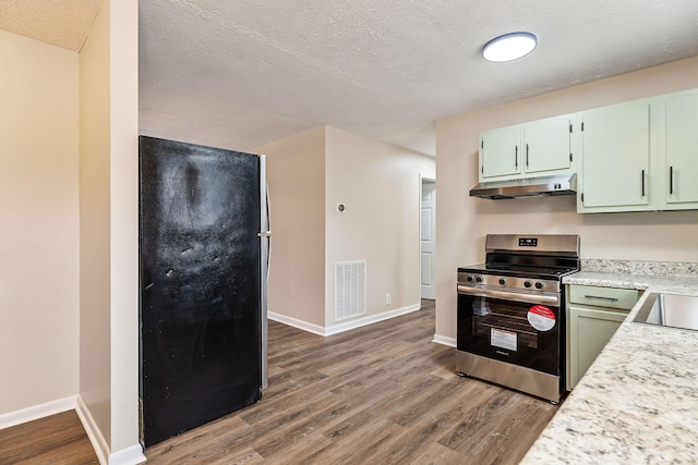 kitchen featuring hardwood / wood-style flooring, green cabinetry, appliances with stainless steel finishes, and a textured ceiling