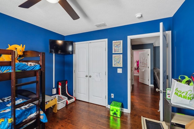 bedroom featuring a textured ceiling, dark hardwood / wood-style flooring, and a closet