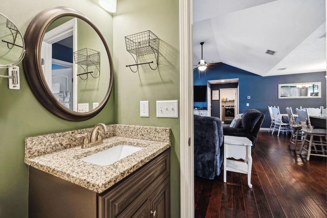 bathroom featuring hardwood / wood-style flooring, vaulted ceiling, vanity, and ceiling fan