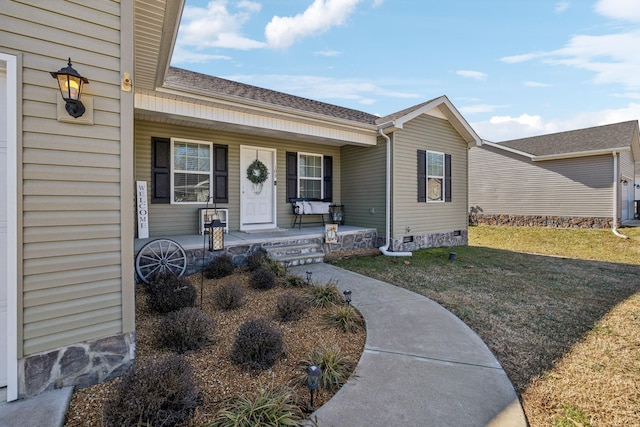 view of exterior entry featuring a porch and a lawn