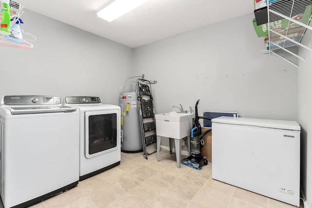 laundry room with washer and clothes dryer, electric water heater, and a textured ceiling