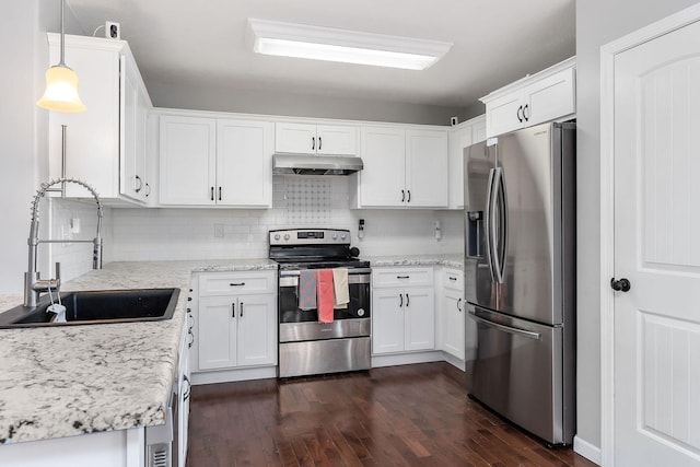 kitchen with sink, appliances with stainless steel finishes, pendant lighting, light stone countertops, and white cabinets