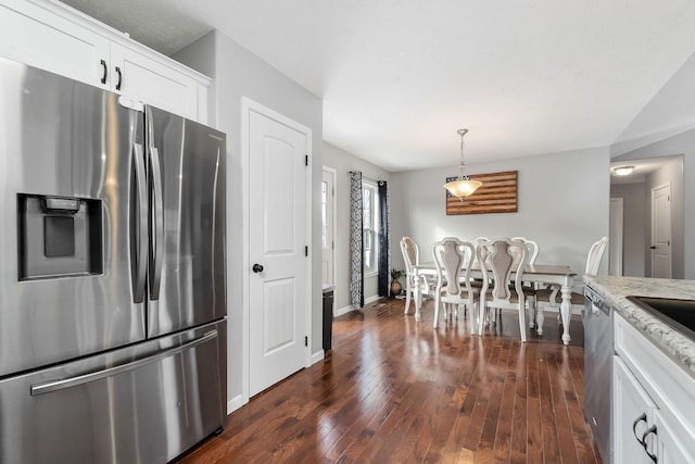 kitchen with white cabinetry, appliances with stainless steel finishes, dark hardwood / wood-style flooring, pendant lighting, and light stone countertops