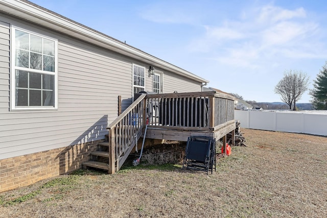 rear view of property featuring a wooden deck and a yard