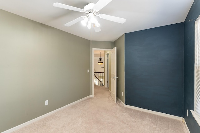 carpeted spare room with ceiling fan