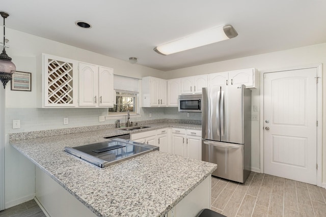 kitchen featuring pendant lighting, white cabinetry, stainless steel appliances, and sink