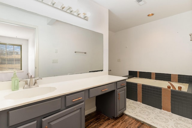 bathroom featuring vanity, wood-type flooring, and a bathtub