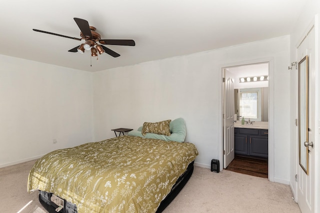 carpeted bedroom featuring ceiling fan, ensuite bathroom, and sink