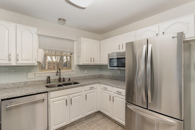 kitchen with white cabinetry, appliances with stainless steel finishes, sink, and tasteful backsplash