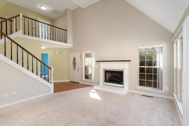 unfurnished living room featuring plenty of natural light, a premium fireplace, and carpet