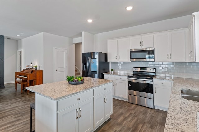 kitchen with white cabinetry, light stone counters, and appliances with stainless steel finishes