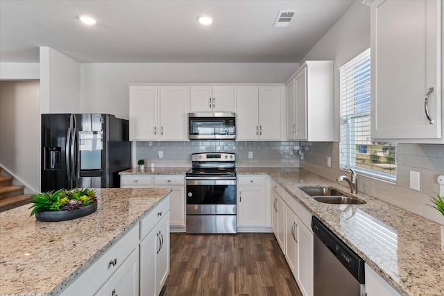 kitchen with sink, stainless steel appliances, white cabinets, and light stone countertops