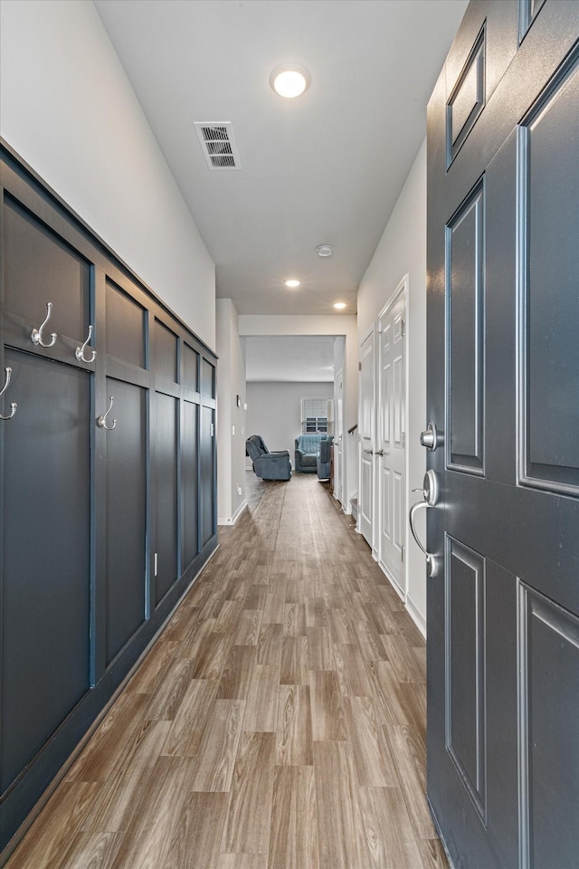 corridor with light hardwood / wood-style floors