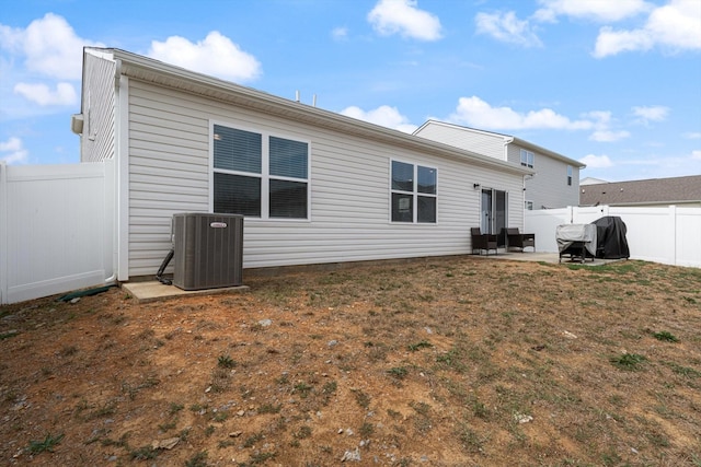 rear view of house featuring a patio, a yard, and cooling unit