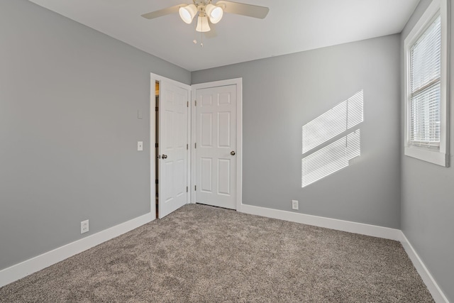 carpeted spare room featuring ceiling fan