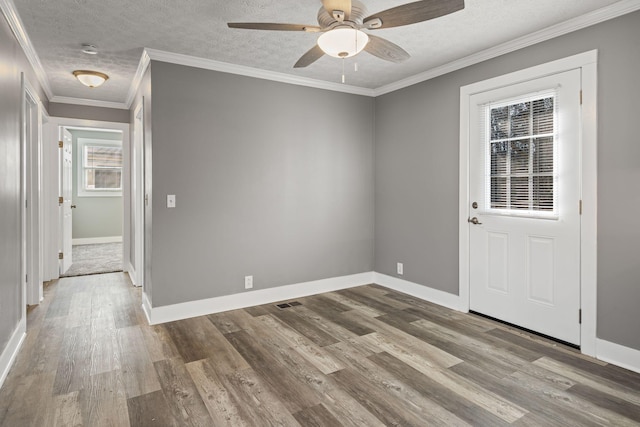 spare room featuring ceiling fan, ornamental molding, light hardwood / wood-style flooring, and a textured ceiling