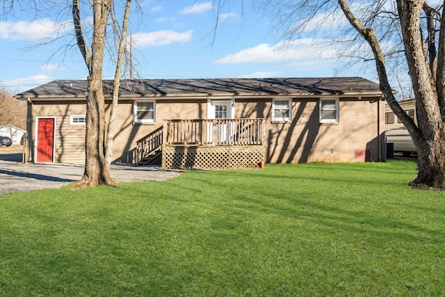 rear view of property featuring a wooden deck and a yard