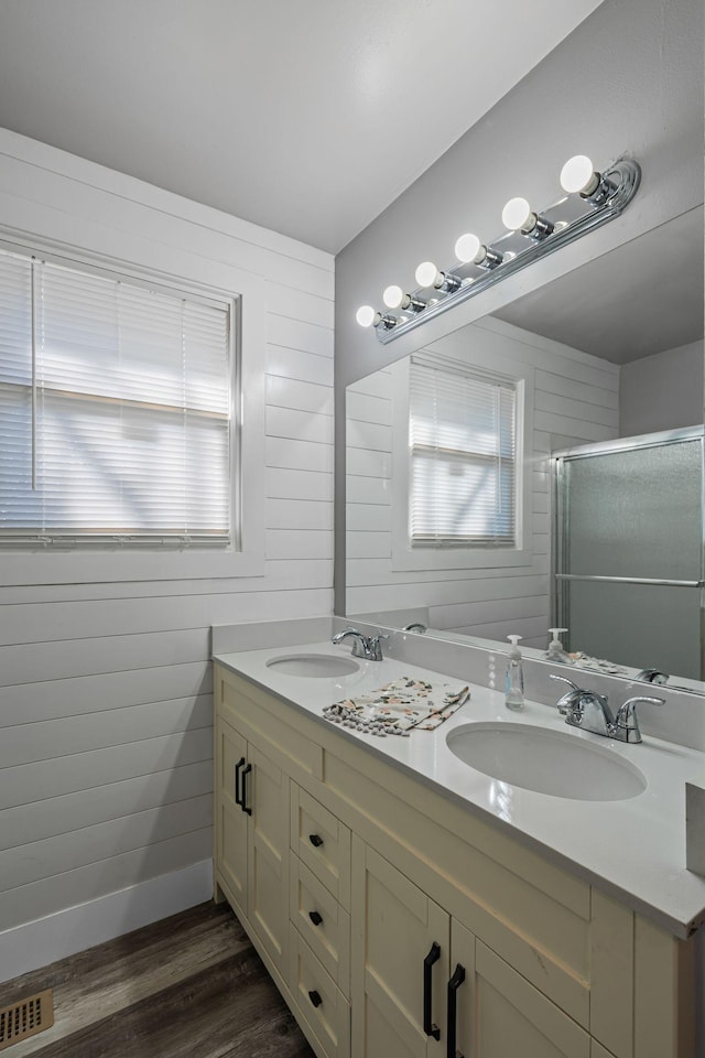 bathroom featuring vanity, hardwood / wood-style floors, plenty of natural light, and a shower with door