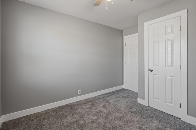 unfurnished room featuring dark carpet and ceiling fan