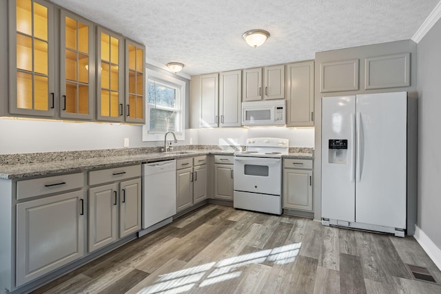 kitchen featuring light stone counters, white appliances, dark hardwood / wood-style flooring, and a textured ceiling