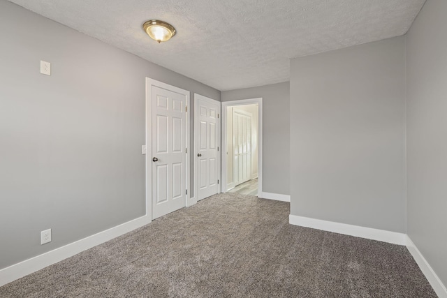 spare room featuring carpet and a textured ceiling