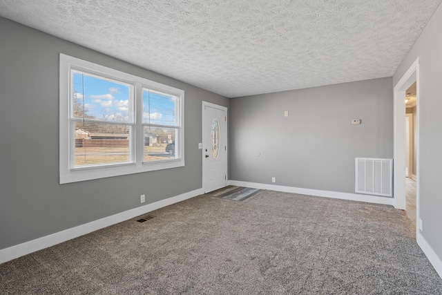 unfurnished room featuring a textured ceiling and carpet