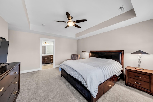 carpeted bedroom with connected bathroom, ceiling fan, and a tray ceiling