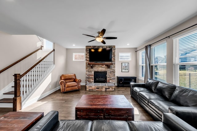 living room with hardwood / wood-style flooring, ceiling fan, and a fireplace