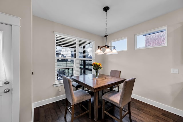 dining area with a notable chandelier and dark hardwood / wood-style floors