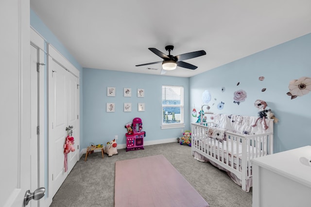 bedroom featuring light carpet, a crib, a closet, and ceiling fan