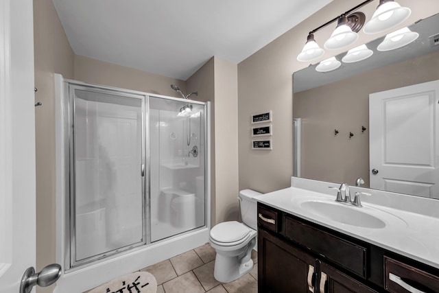 bathroom with vanity, tile patterned floors, toilet, and walk in shower