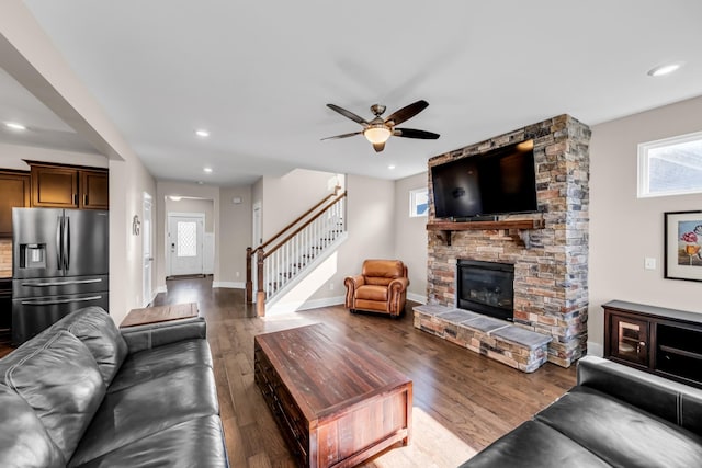 living room featuring wood-type flooring, ceiling fan, and a fireplace