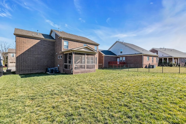 rear view of house featuring a sunroom, a yard, and cooling unit