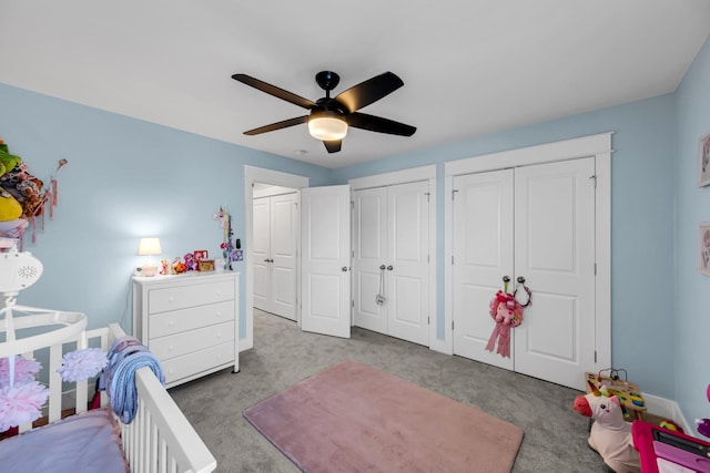 carpeted bedroom with multiple closets and ceiling fan