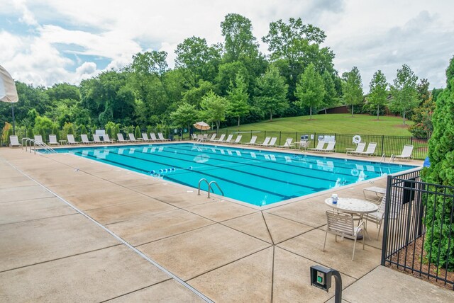 view of swimming pool with a patio area and a lawn