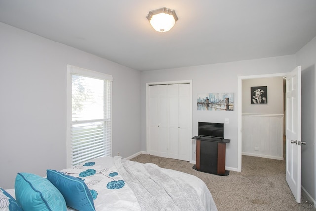 bedroom featuring light colored carpet and a closet