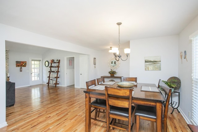 dining space featuring light hardwood / wood-style floors and a notable chandelier