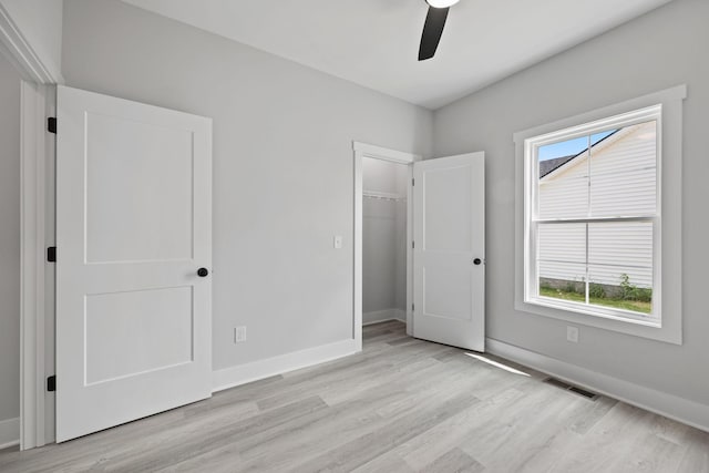 unfurnished bedroom with ceiling fan, light wood-style flooring, visible vents, baseboards, and a closet